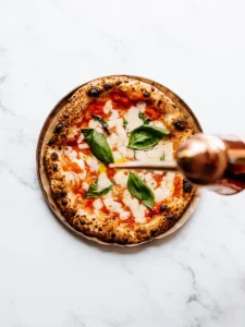 Pizza Margherita con mozzarella e pomodoro foto Foto di Rene Strgar: https://www.pexels.com/it-it/foto/pizza-margherita-classica-su-superficie-di-marmo-35068608/